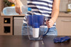 Brita waterkan wordt gevuld, vergeleken met een onder-aanrecht waterfilter